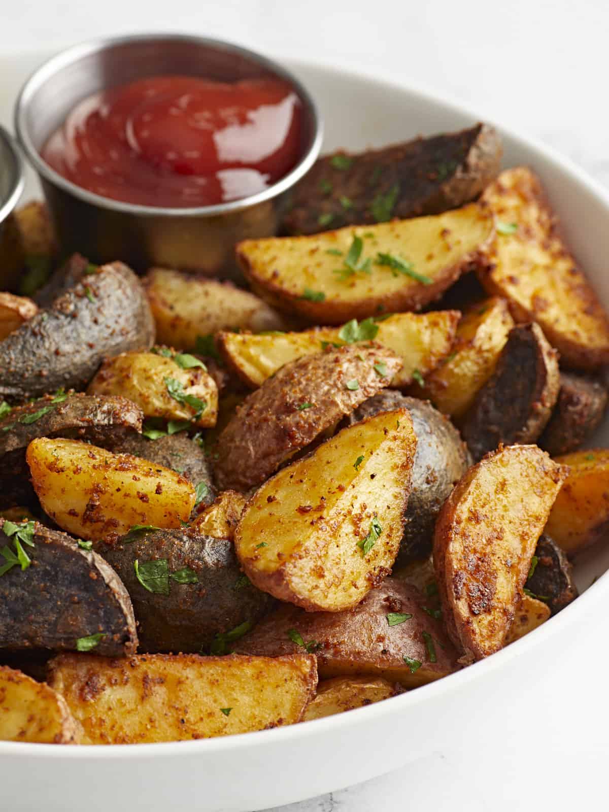 air fryer potatoes in a bowl with ketchup.