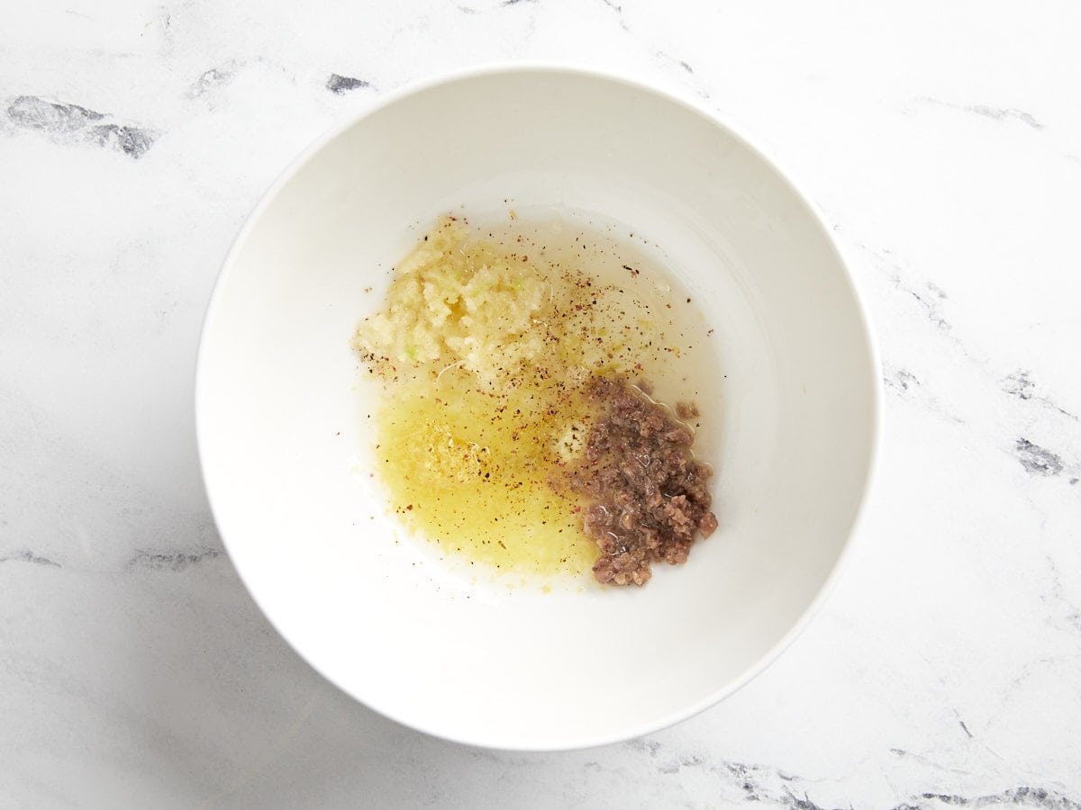 Caesar dressing ingredients in a bowl.