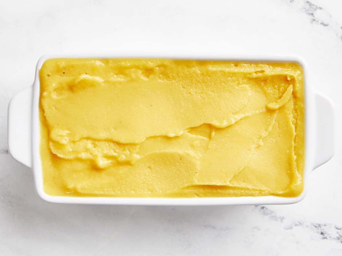 frozen mango sorbet in a white rectangular dish.