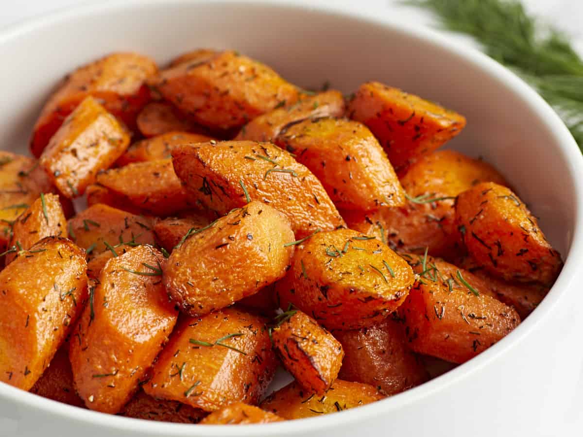 Close up side view of Air Fryer Carrots in a white serving dish.