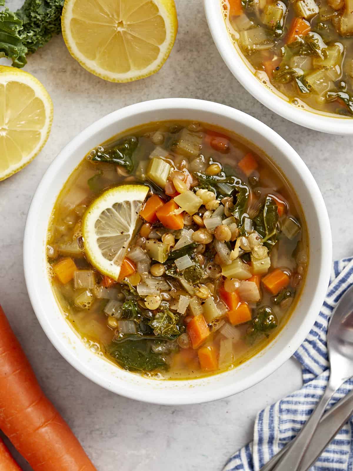 overhead view of a bowl of mediterranean lentil soup with lemon slices.