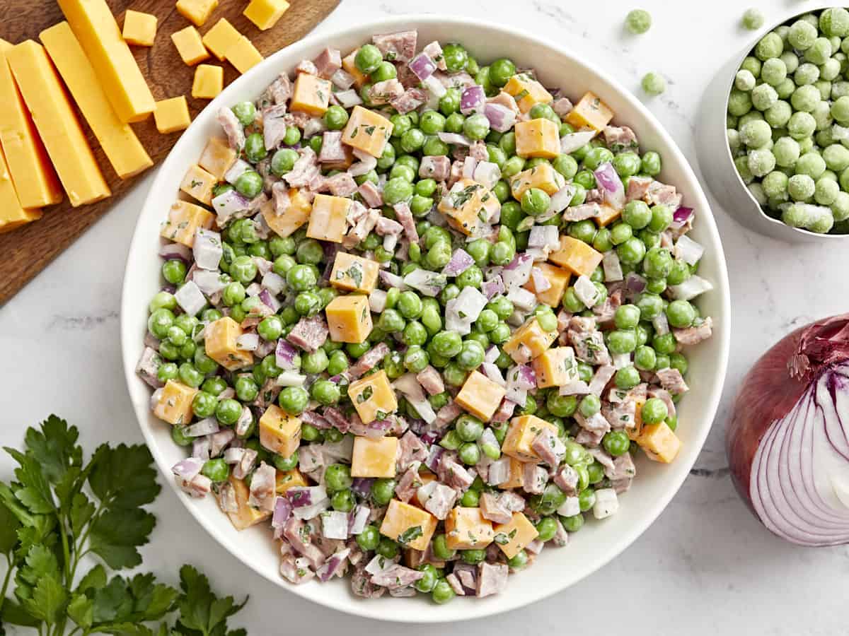 overhead view of pea salad in a white bowl.