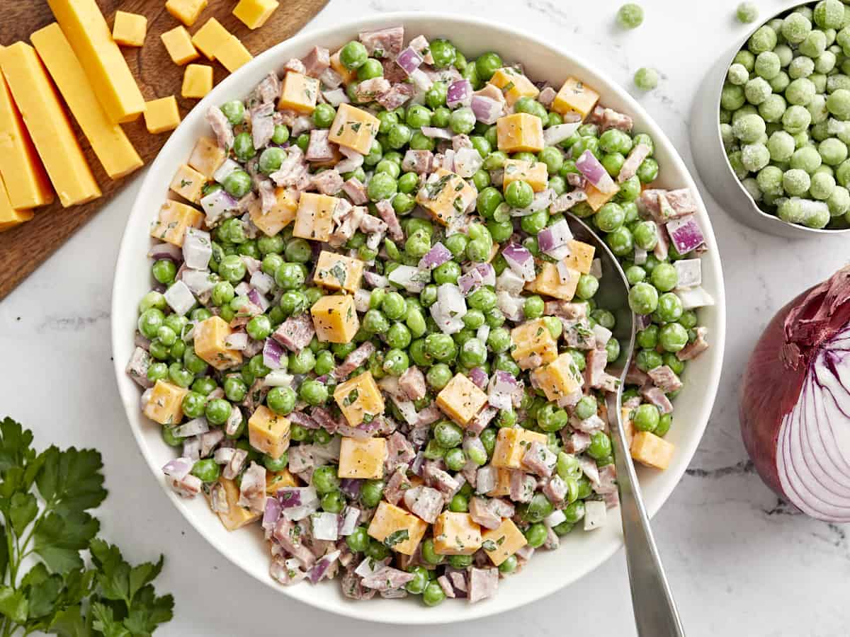 overhead view of pea salad with a spoon.