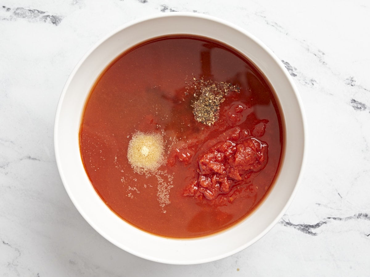 Overhead view of homemade tomato sauce ingredients in a medium bowl.