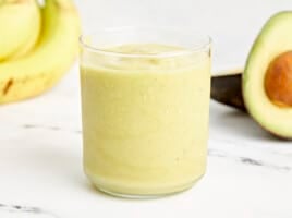 an avocado smoothie in a clear glass.