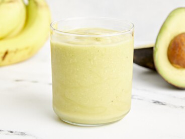 an avocado smoothie in a clear glass.