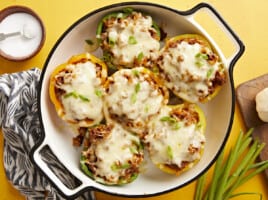 Overhead view of chorizo stuffed bell peppers in a round baking dish.