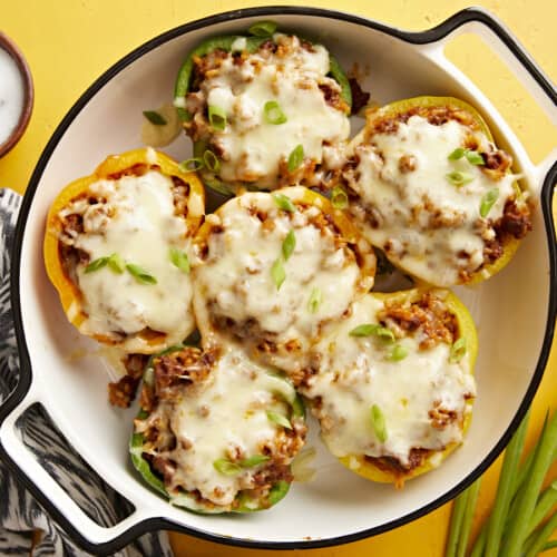 Overhead view of chorizo stuffed bell peppers in a round baking dish.