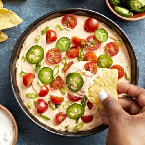 Overhead view of Taco Dip in a serving bowl with a chip scooping some out.