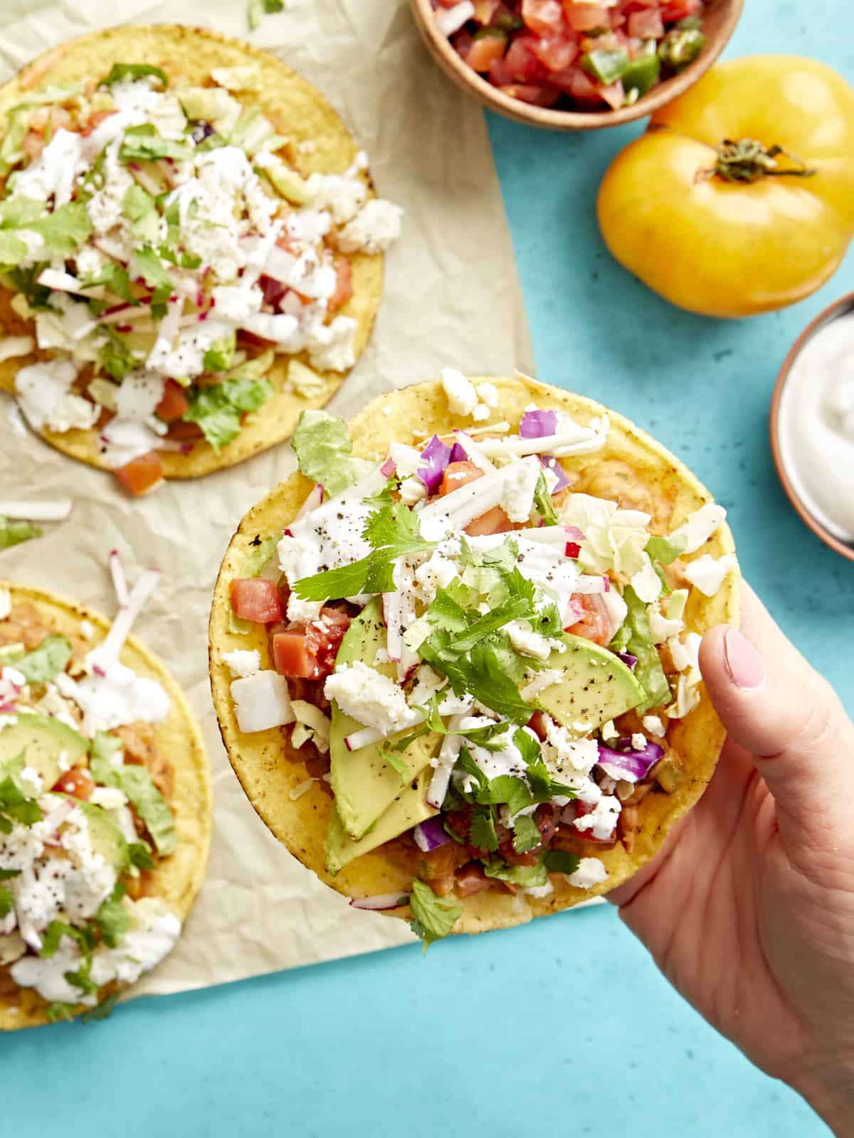 close up of a hand holding a tostada.