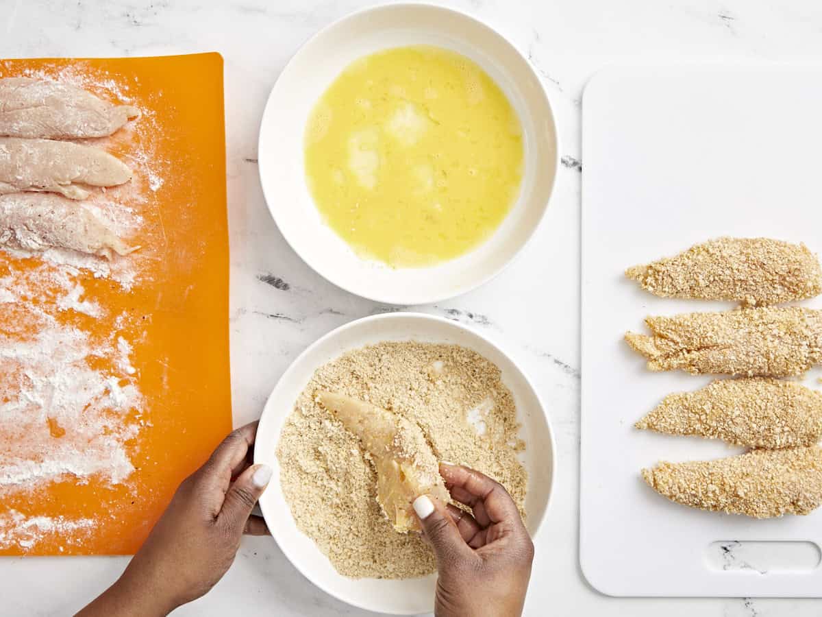 Overhead view of chicken tenders breading station.