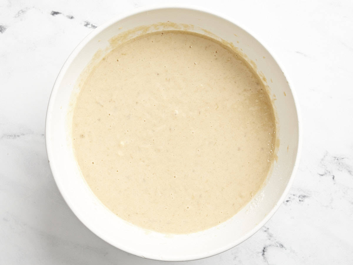 banana cake batter in a white bowl.