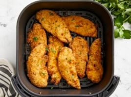 Basket of crispy chicken tenders from an air fryer.