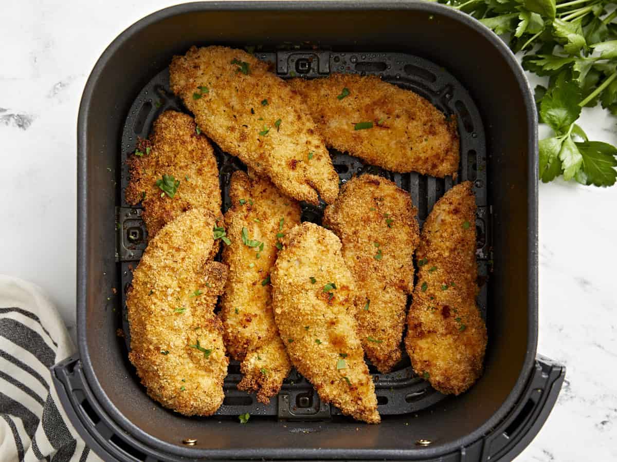 Overhead view of air fryer chicken tenders in an air fryer basket.