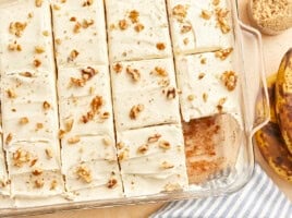 a cut banana cake missing a slice in a glass baking dish.