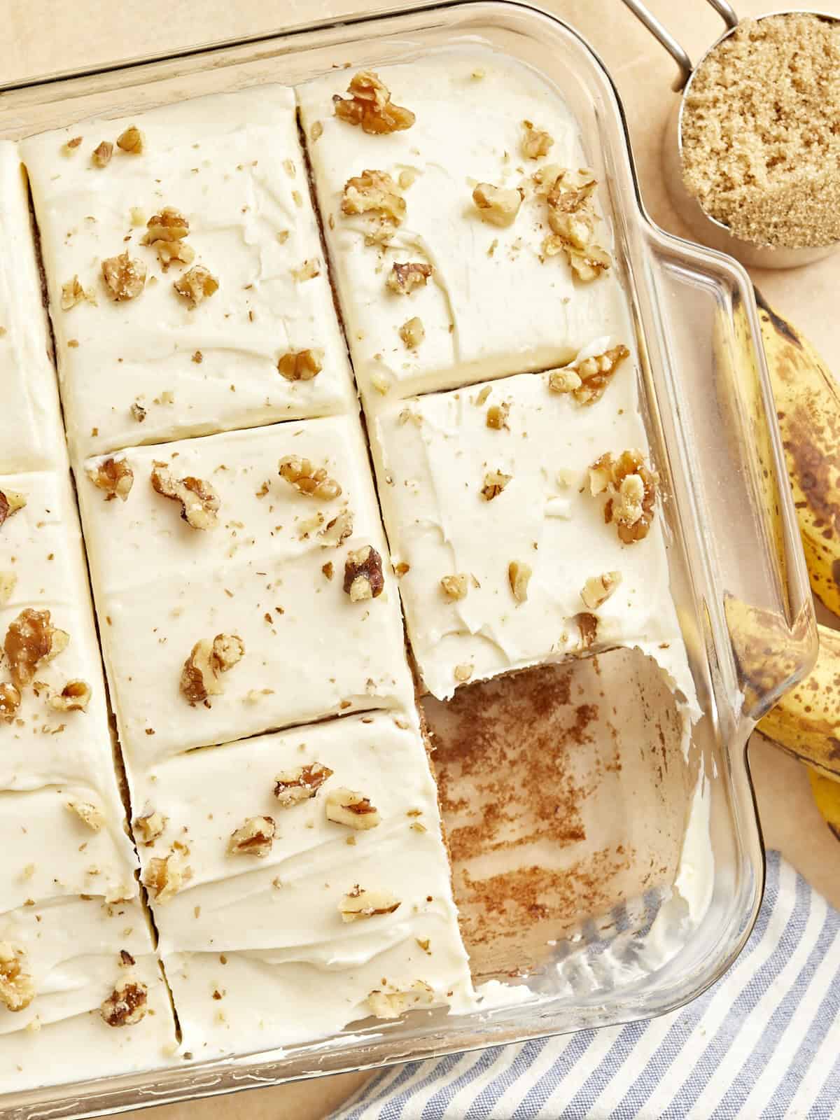 a cut banana cake missing a slice in a glass baking dish.