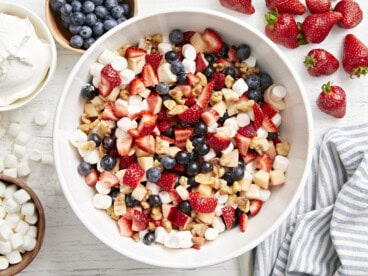 overhead view of a bowl of red white and blue fruit salad.