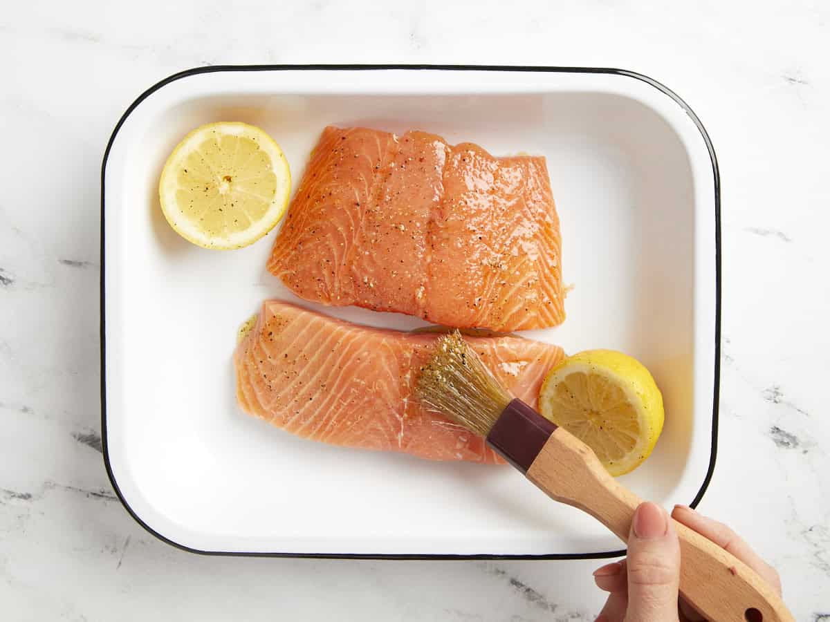 brushing oil over salmon fillets.