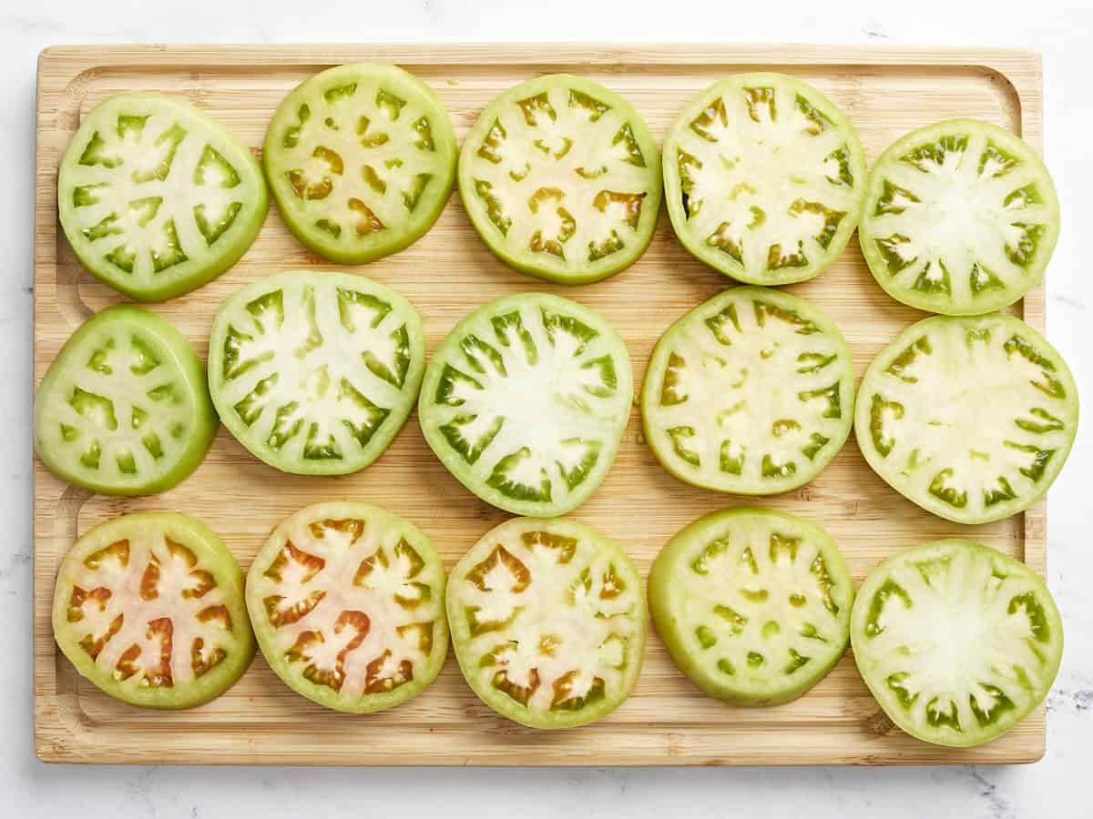 sliced green tomatoes on a cutting board.