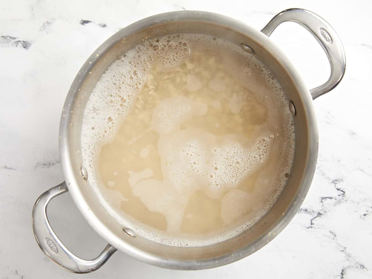 barley cooking in a pot of boiling water.