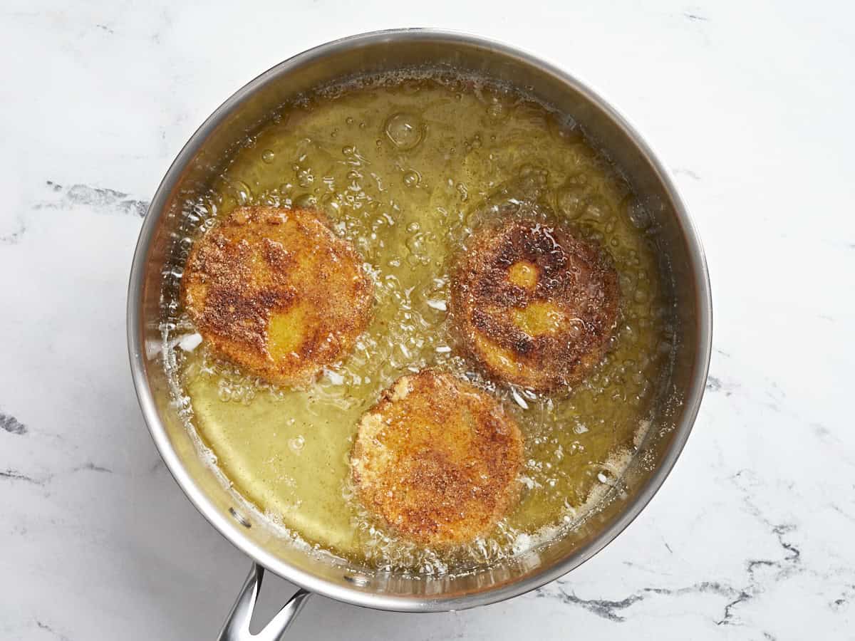 3 fried green tomato slices in oil.