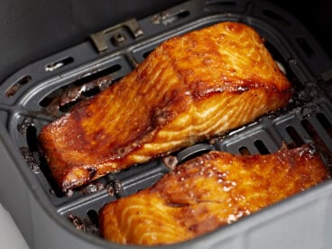 close up of air fryer salmon filets in an air fryer basket.