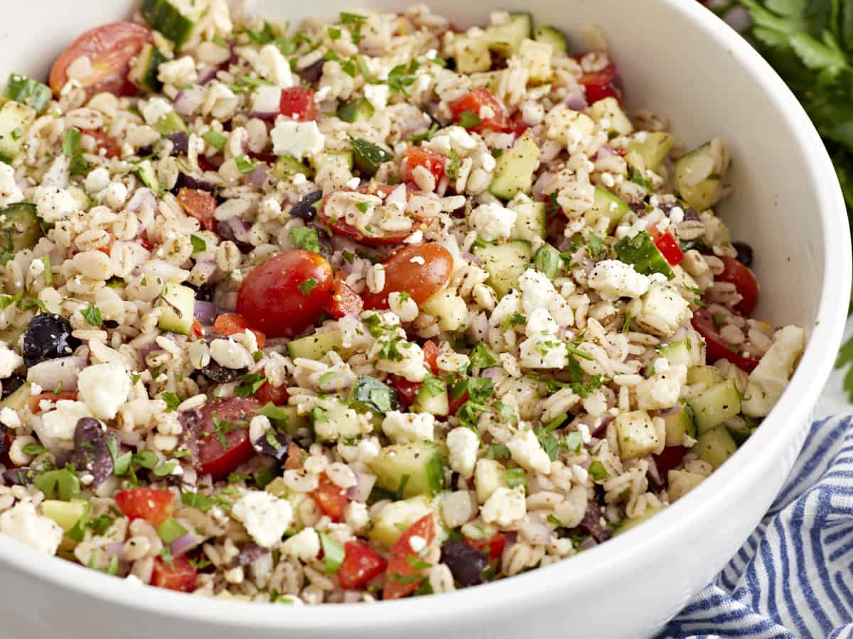 closeup of barley salad in a white bowl.