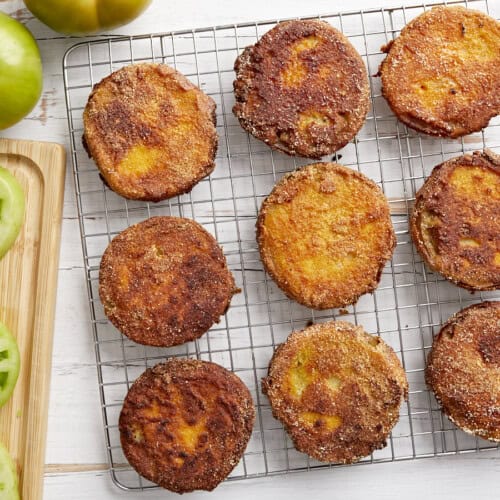 overhead view of fried green tomatoes on a wire rack.