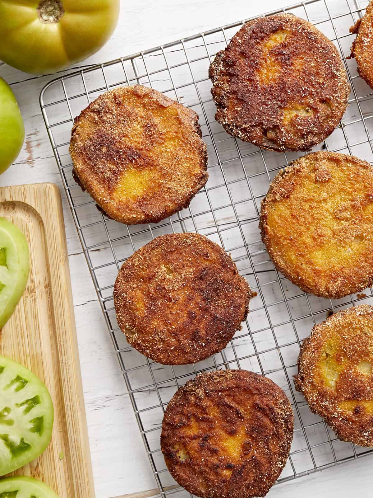 overhead view of fried green tomatoes on a wire rack.