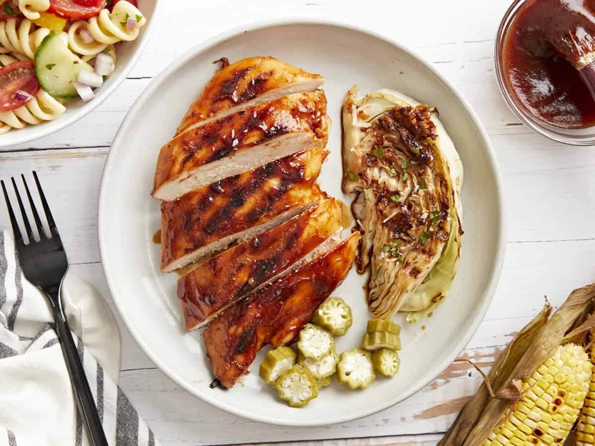 overhead view of a serving of grilled bbq chicken with okra and grilled lettuce.