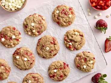 overhead view of 12 strawberry cookies on a parchment-lined wire rack.