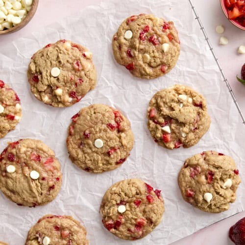 overhead view of 12 strawberry cookies on a parchment-lined wire rack.