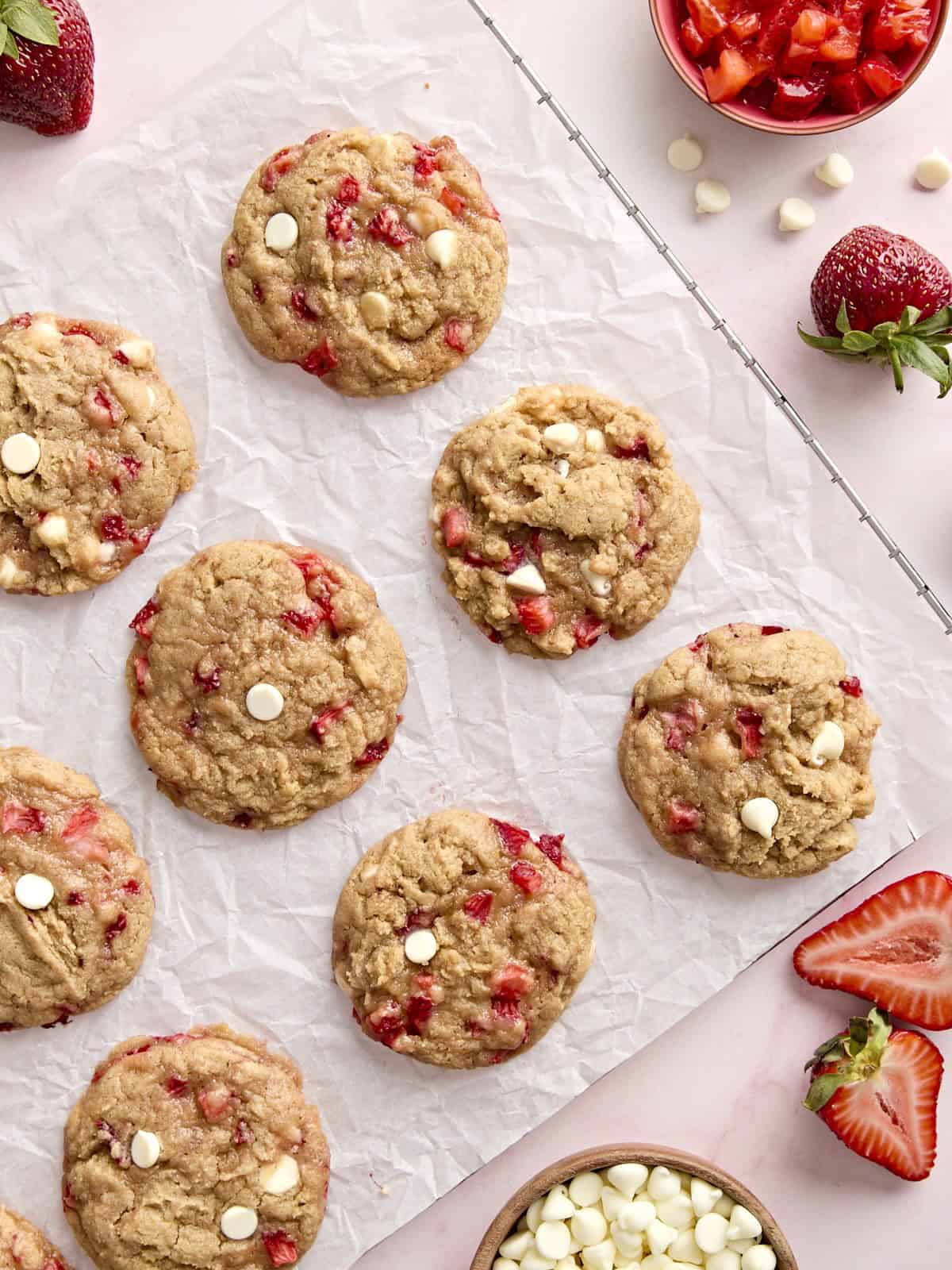 overhead view of 12 strawberry cookies on a parchment-lined wire rack.