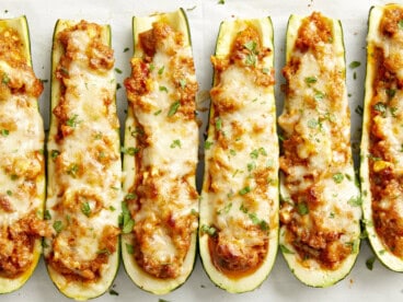 Overhead close up view of Zucchini boats on parchment paper.