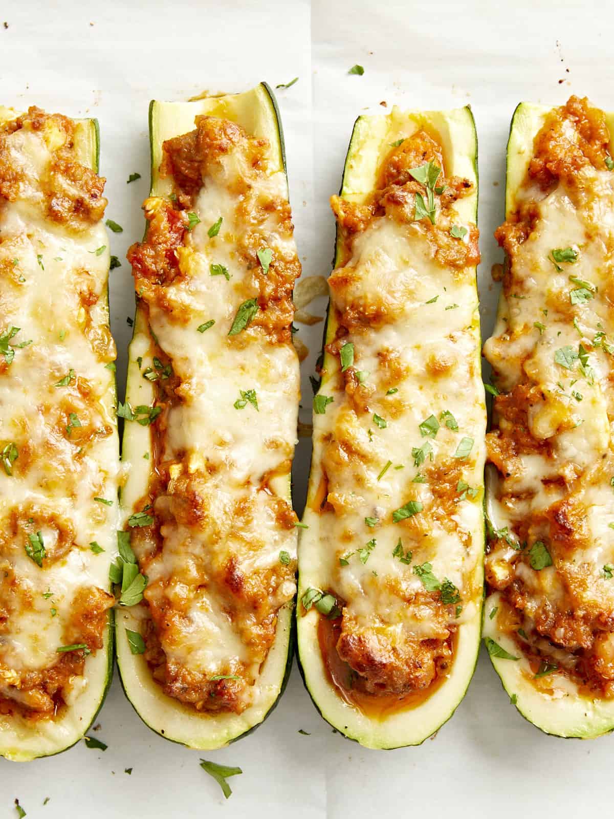 Overhead close up view of Zucchini boats on parchment paper.