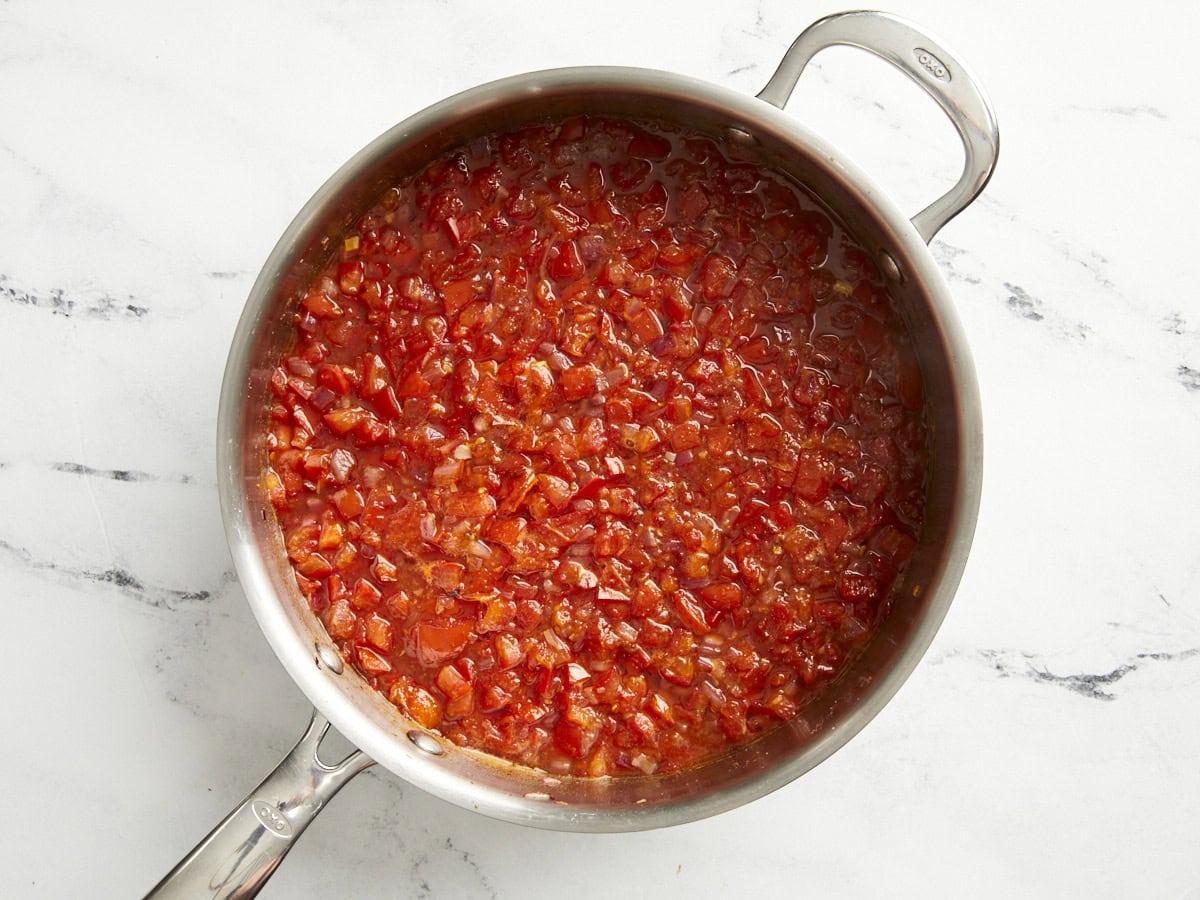 Tomato relish halway through cooking in a pan.