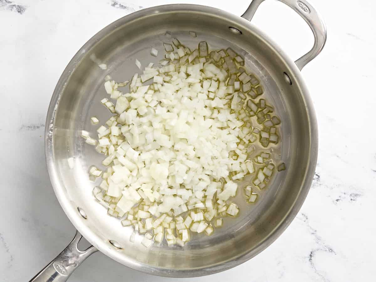 Melted butter and diced onion in a skillet.