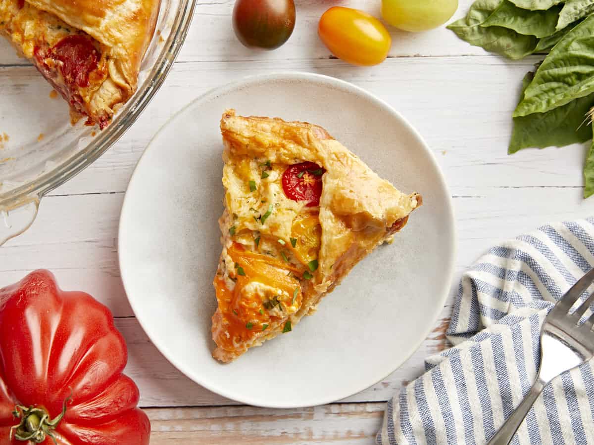 A slice of tomato pie on a plate.