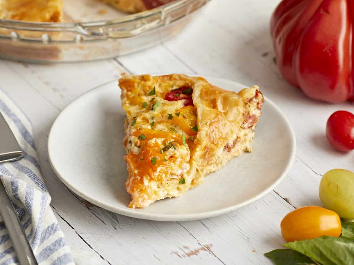 Side view of a slice of tomato pie on a plate.