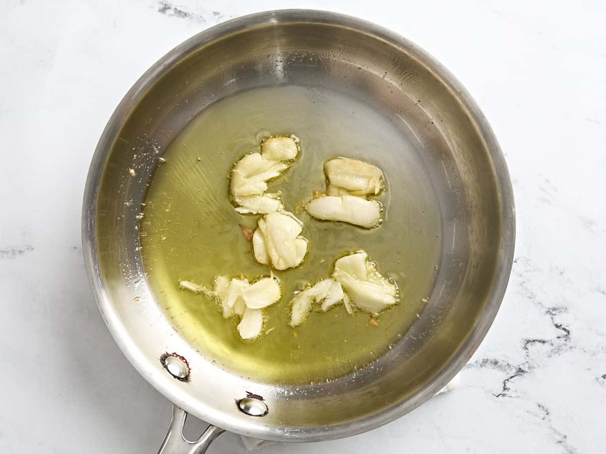 Garlic cloves toasted in hot oil in a pan