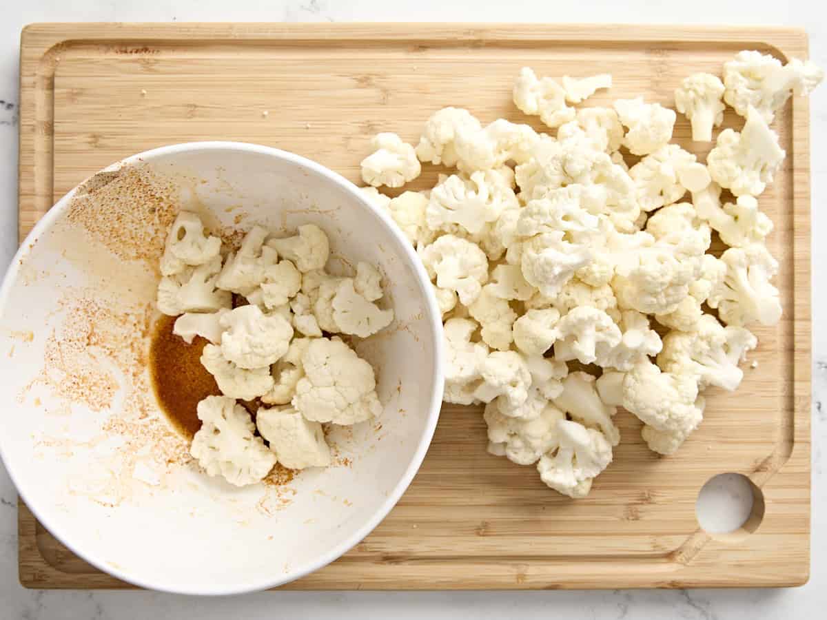 Cauliflower floret being toss in a seasoning mix