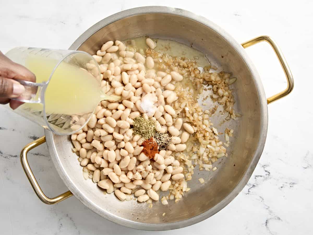 White beans, spices, and chicken broth added to skillet.