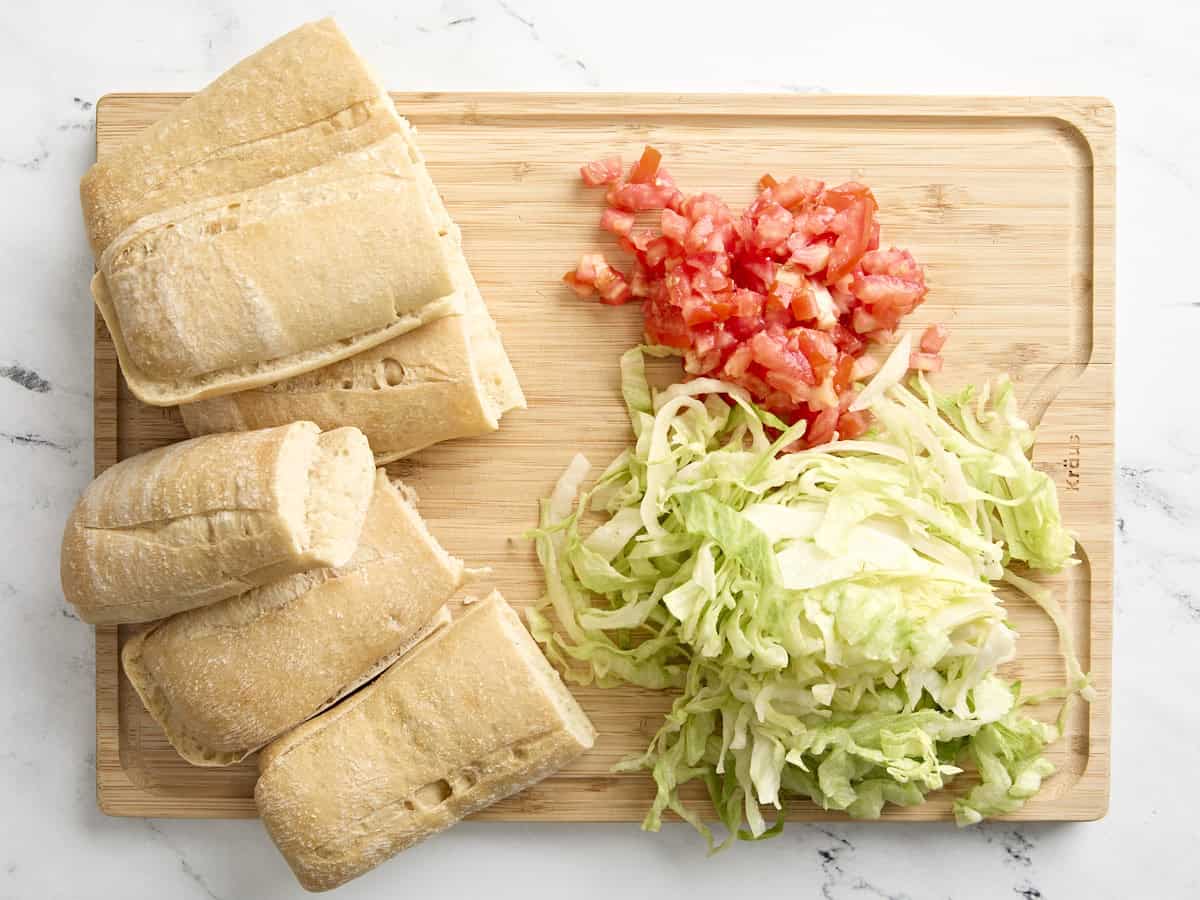 Sliced baguette, tomatoes, and lettuce for shrimp po' boys