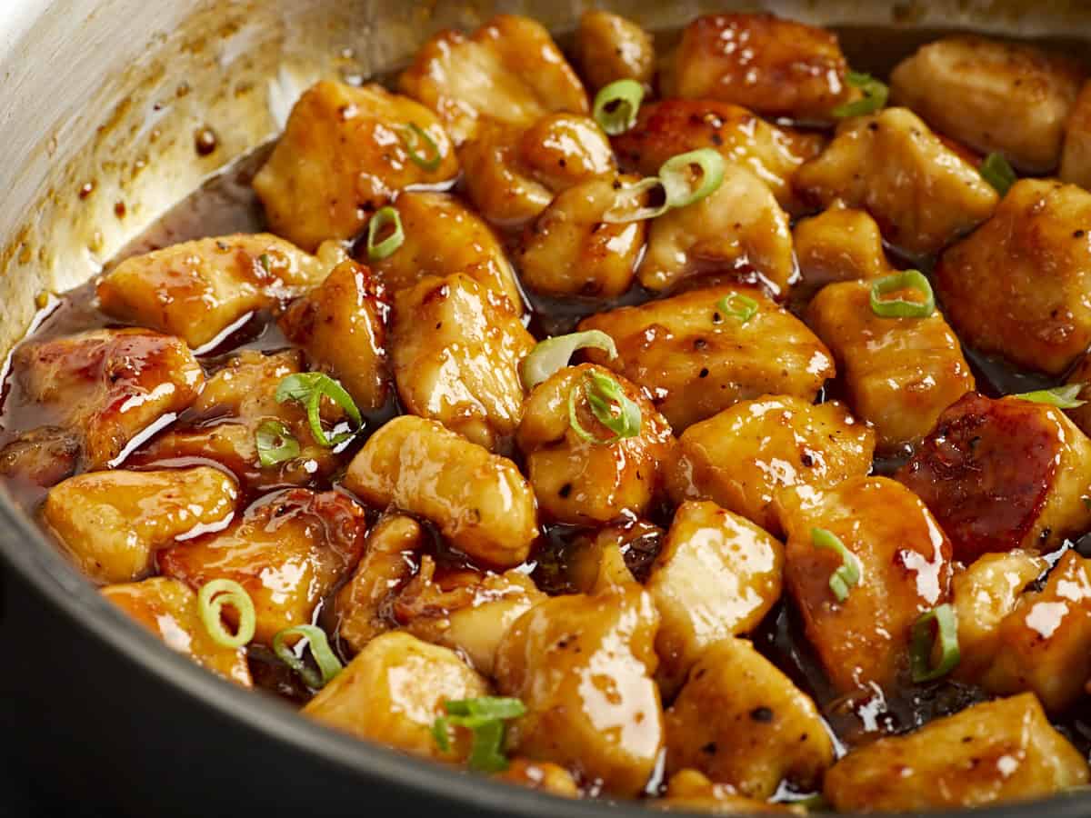 Side close up view of honey garlic chicken in a skillet.