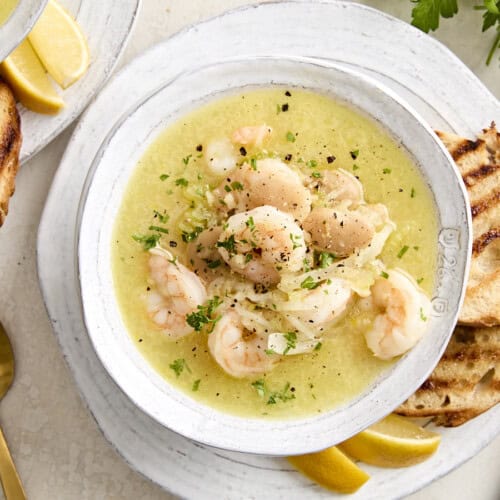 Shrimp and white bean stew in a bowl garnished with fresh herbs