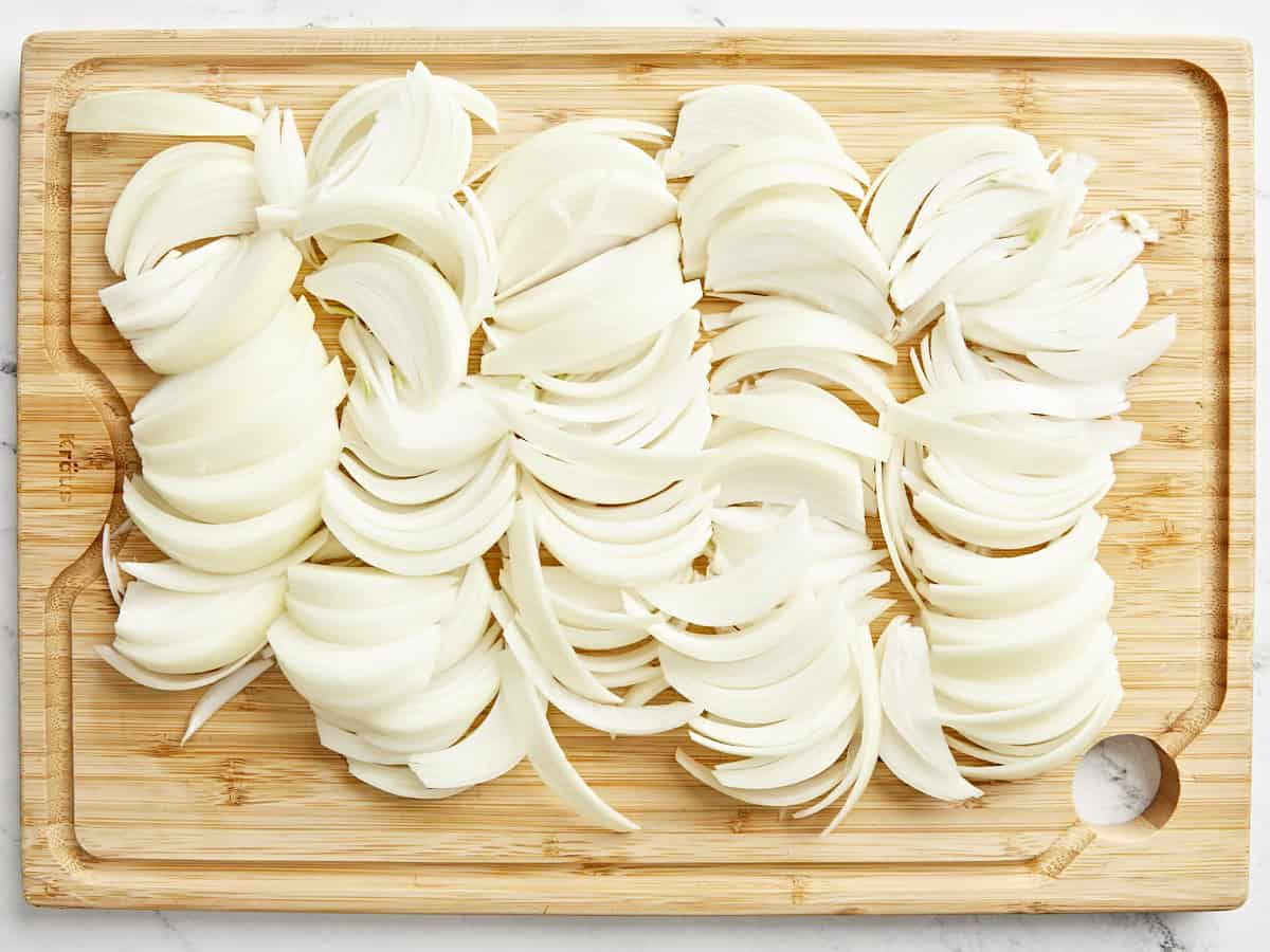 Sliced onions on a chopping board.