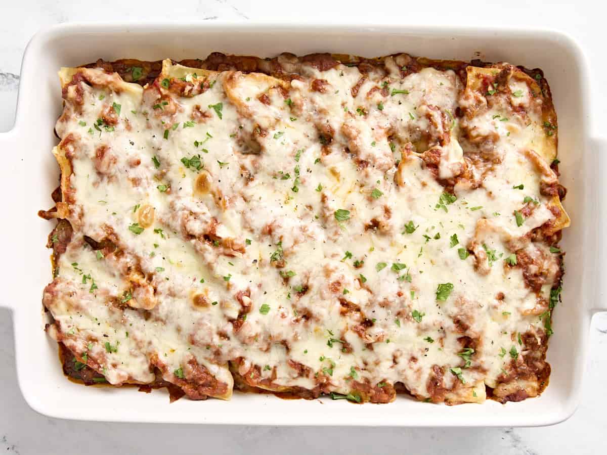 overhead view of cooked stuffed shells with meat in a casserole dish. 