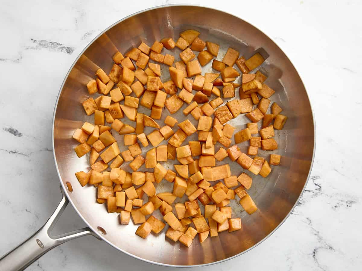 Cooked sweet potatoes in a skillet.