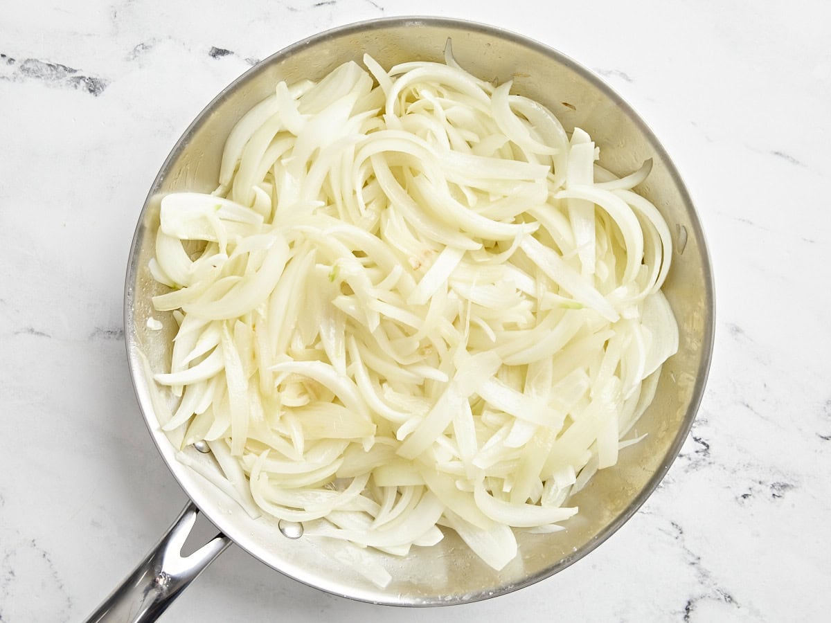 Sliced onions in a pan after being cooked for 10 minutes.