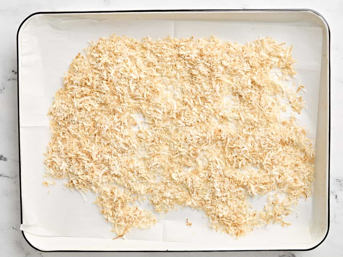 Toasted shredded coconut on a baking sheet.